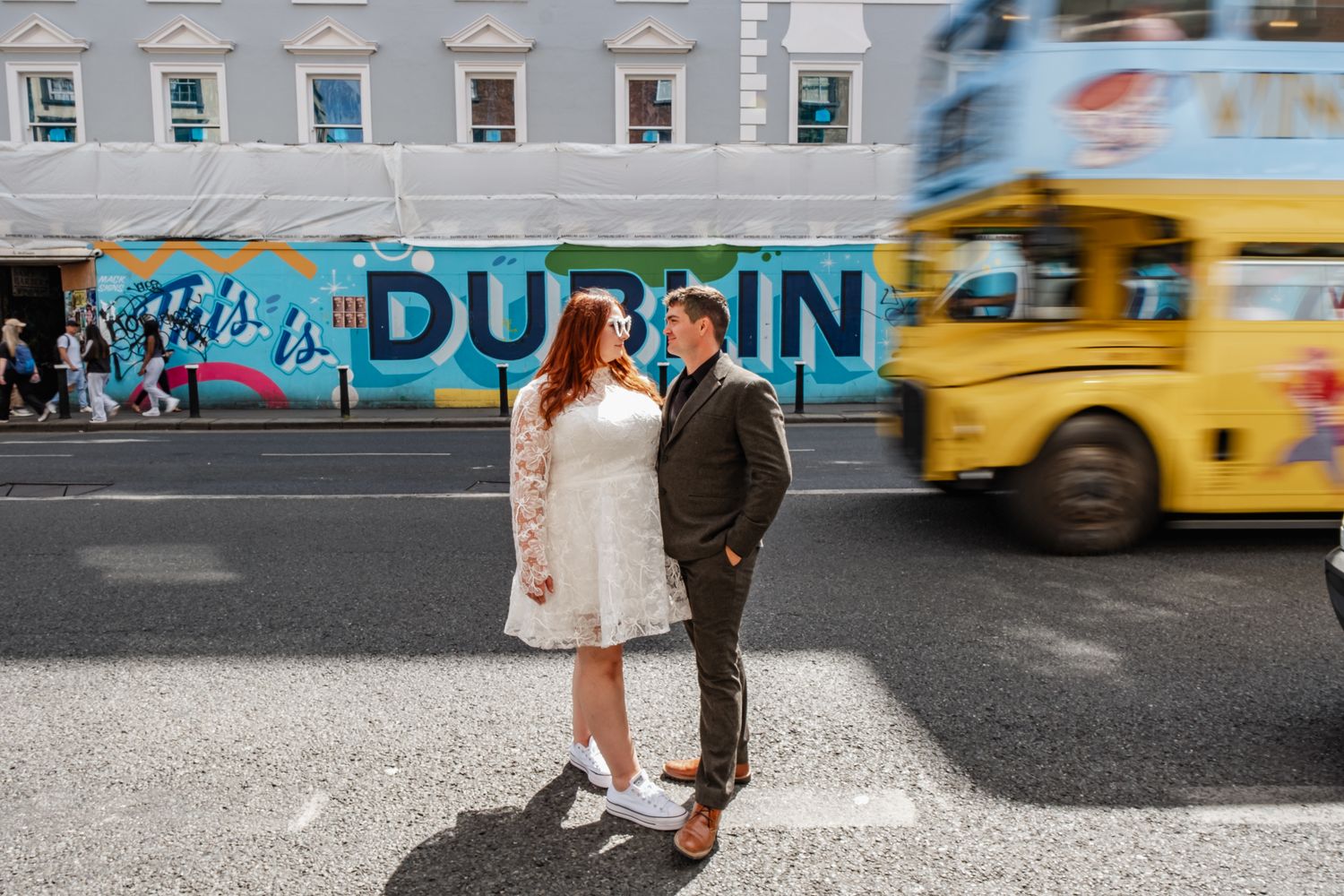 Street art and yellow taxi create colorful backdrop for Dublin city wedding photos.