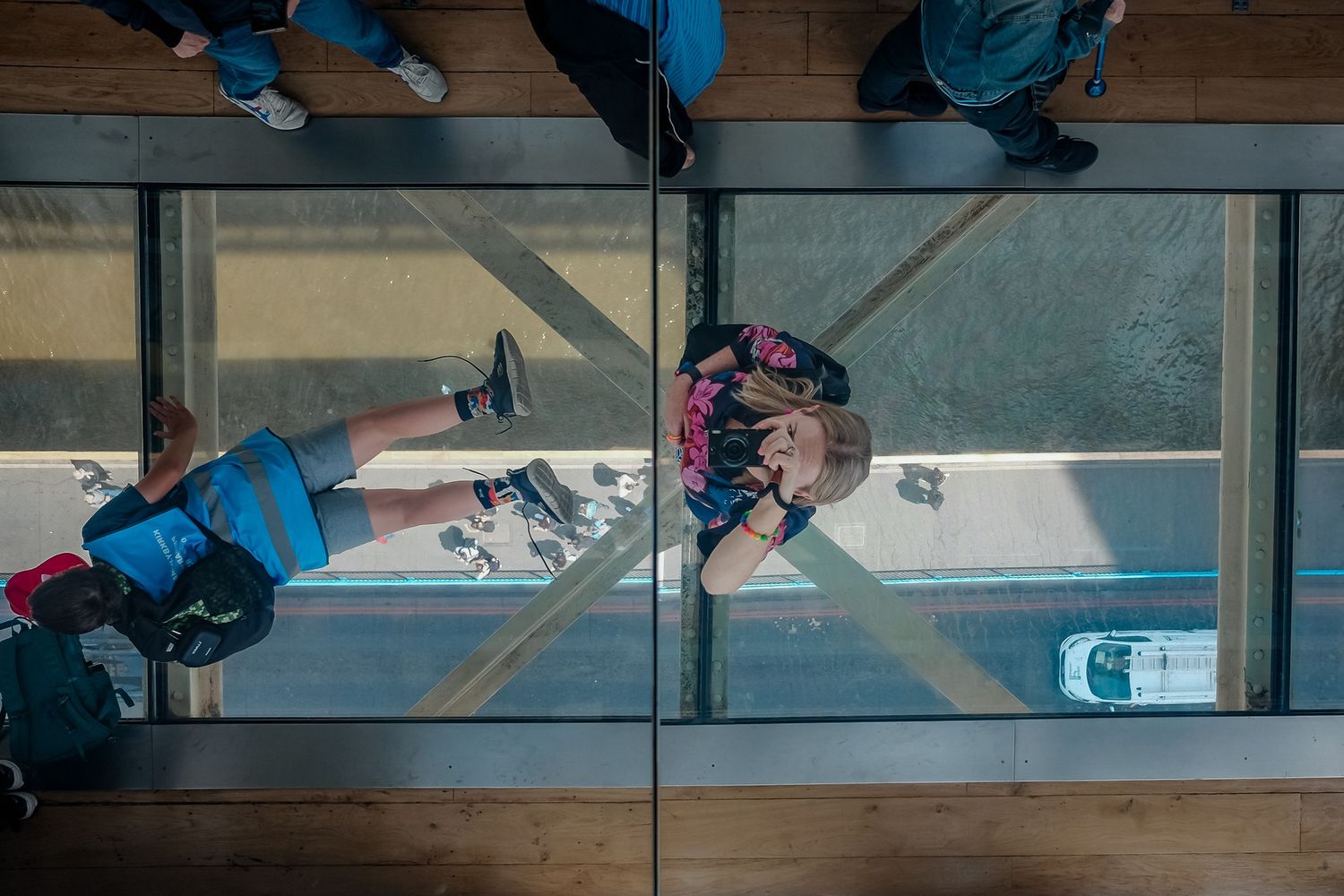 Birds-eye view of people walking across wooden floors in an indoor space.