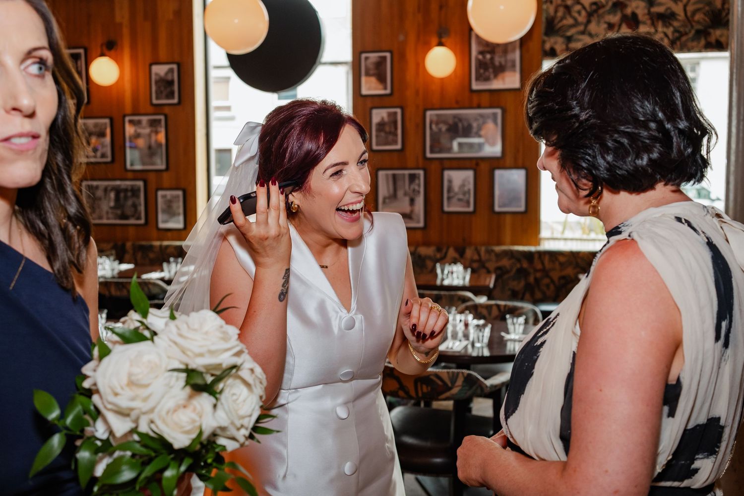 Intimate wedding celebration moment in restaurant with white paper lantern decor.