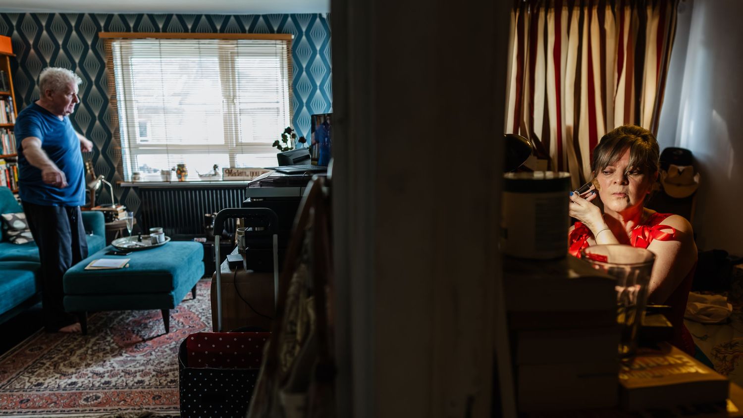 Two areas of a dimly lit room, with blue tones on left and warm light on right.