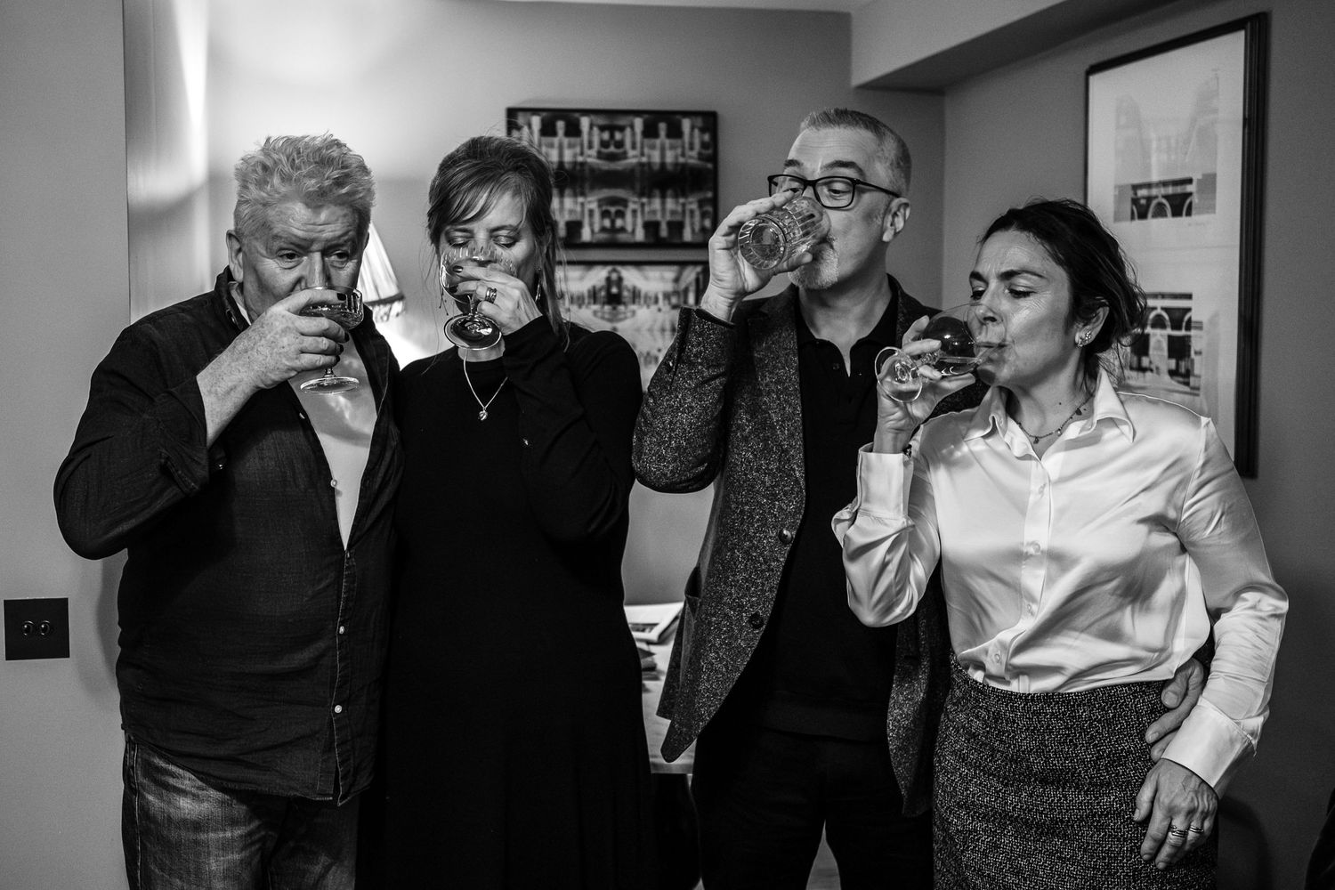 Group of people taking shots together in a casual indoor setting.