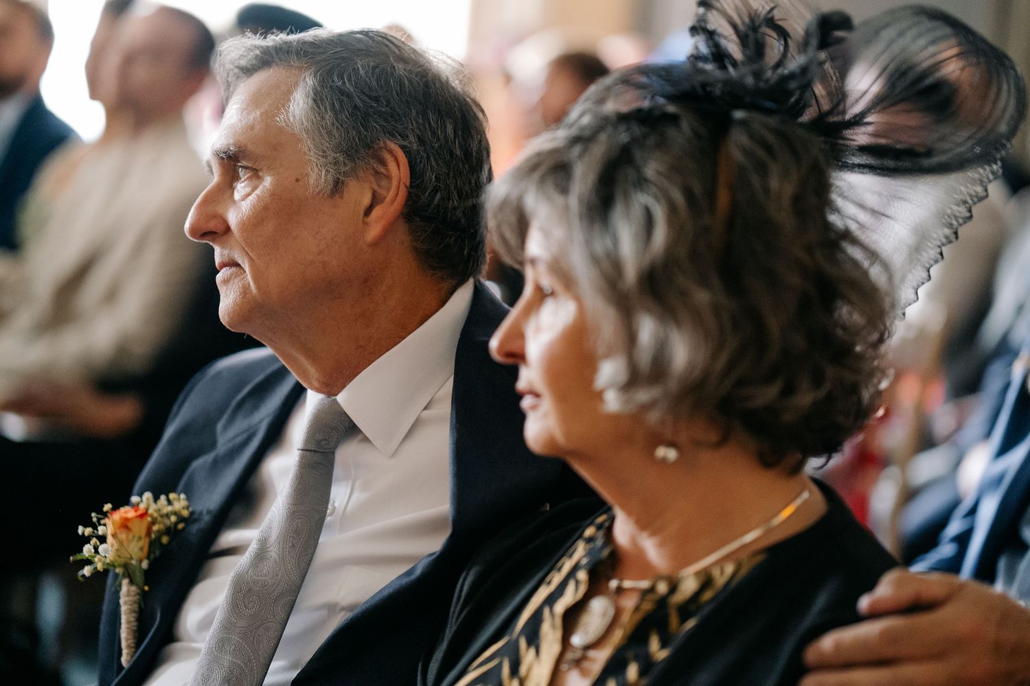 Wedding ceremony guests seated in rows watching the proceedings with natural lighting.