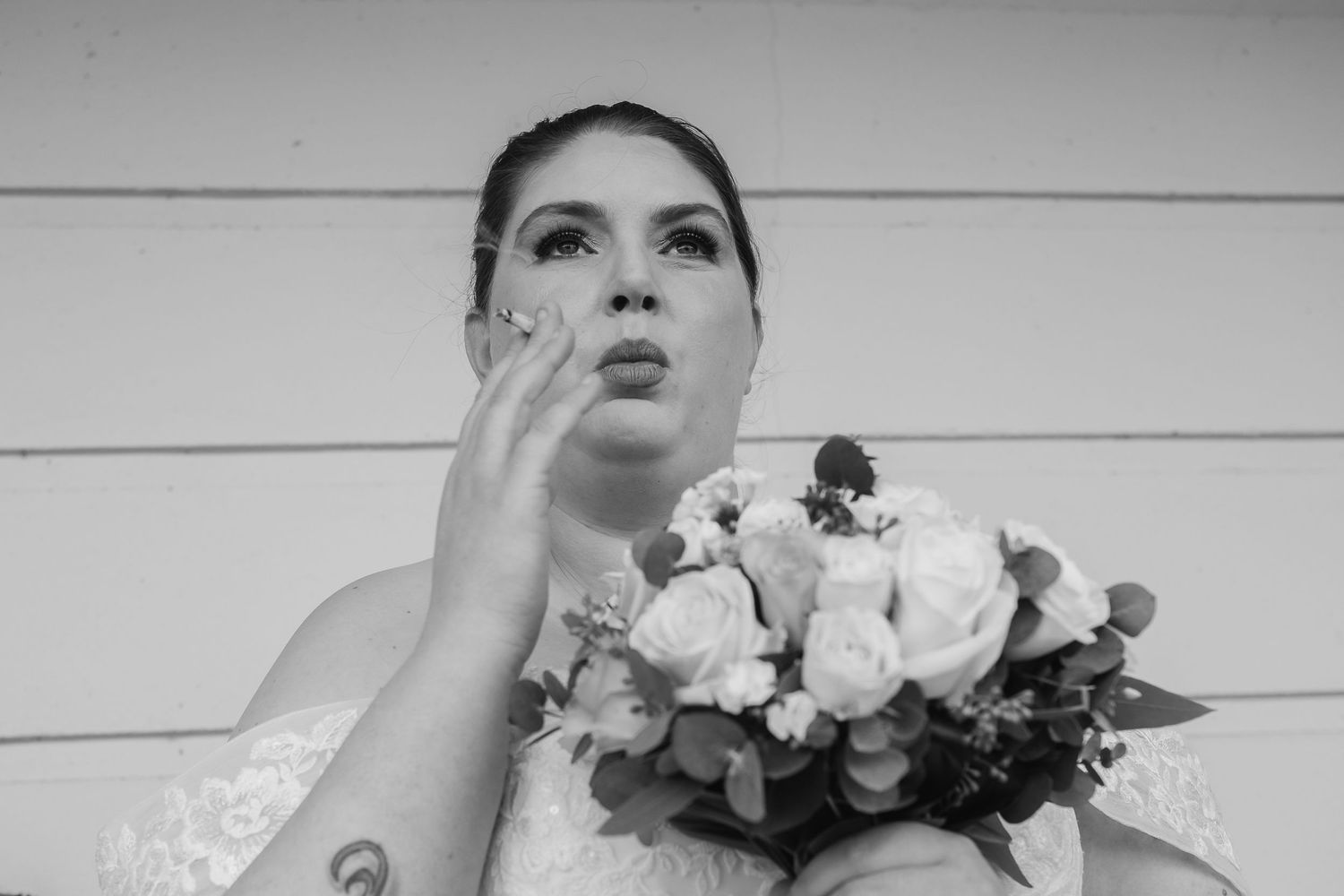 Artistic black and white bridal portrait with floral bouquet.