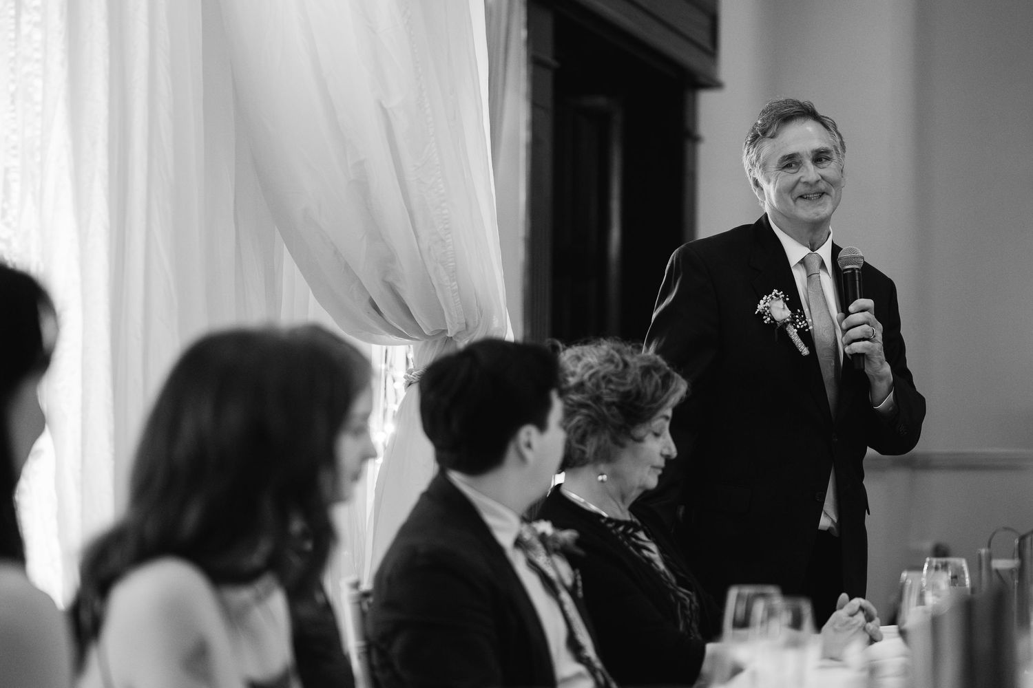 Wedding reception candid moments captured in black and white photography.