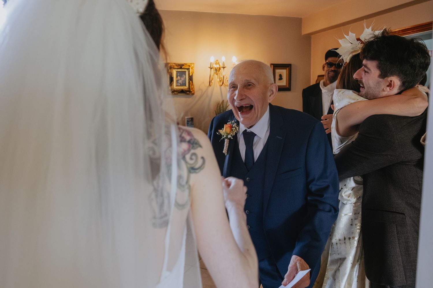A group of wedding guests react with joy and excitement during an emotional moment at the ceremony.