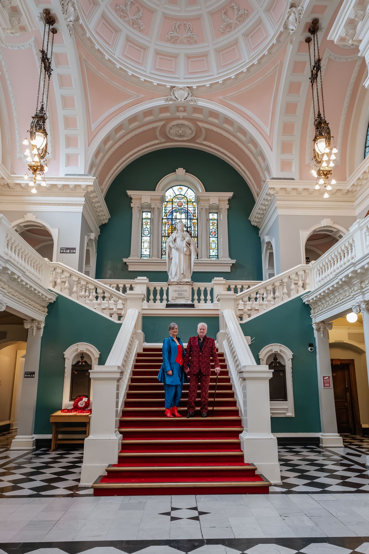 Elegant church interior with pink dome, green walls and ornate white staircase.
