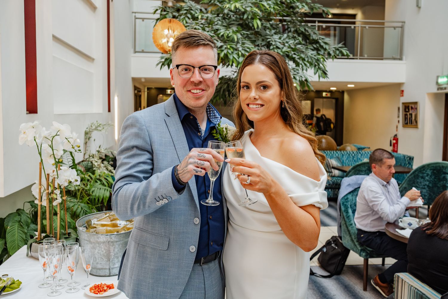 Newlyweds toast with champagne glasses at outdoor reception.