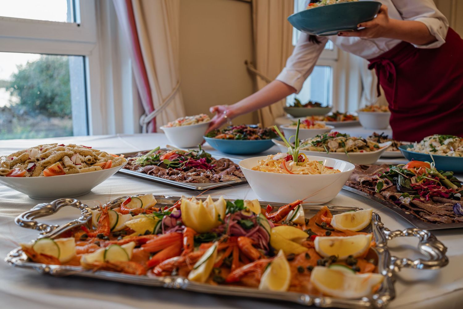 Elegant wedding buffet spread with colorful salads, roasted vegetables, and fresh dishes.