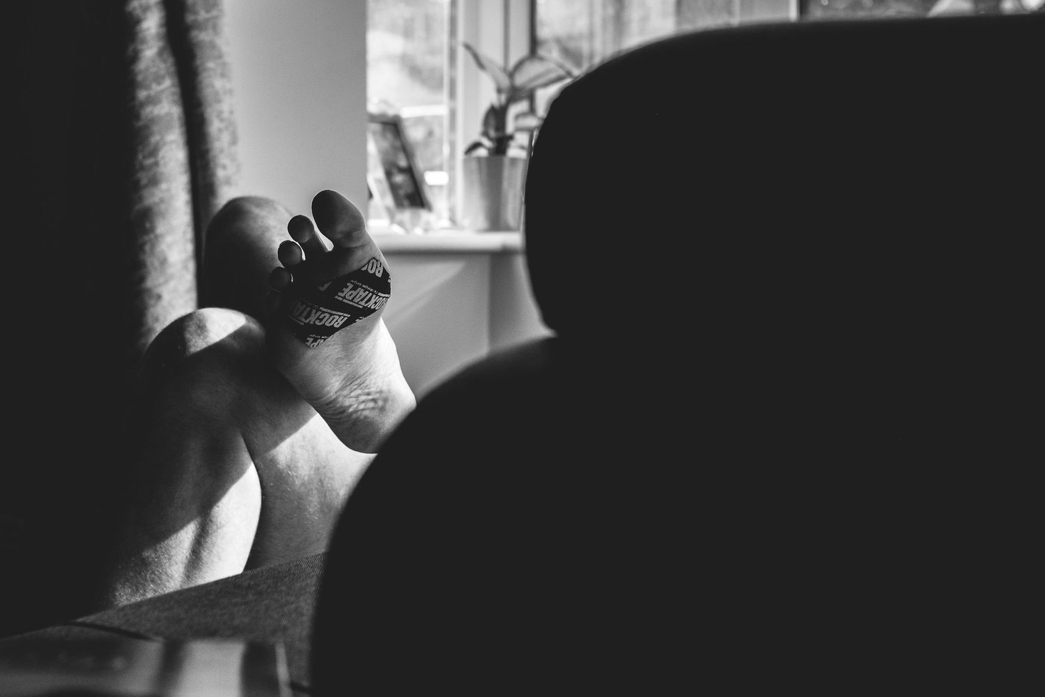 Black and white silhouette of feet against a window background.