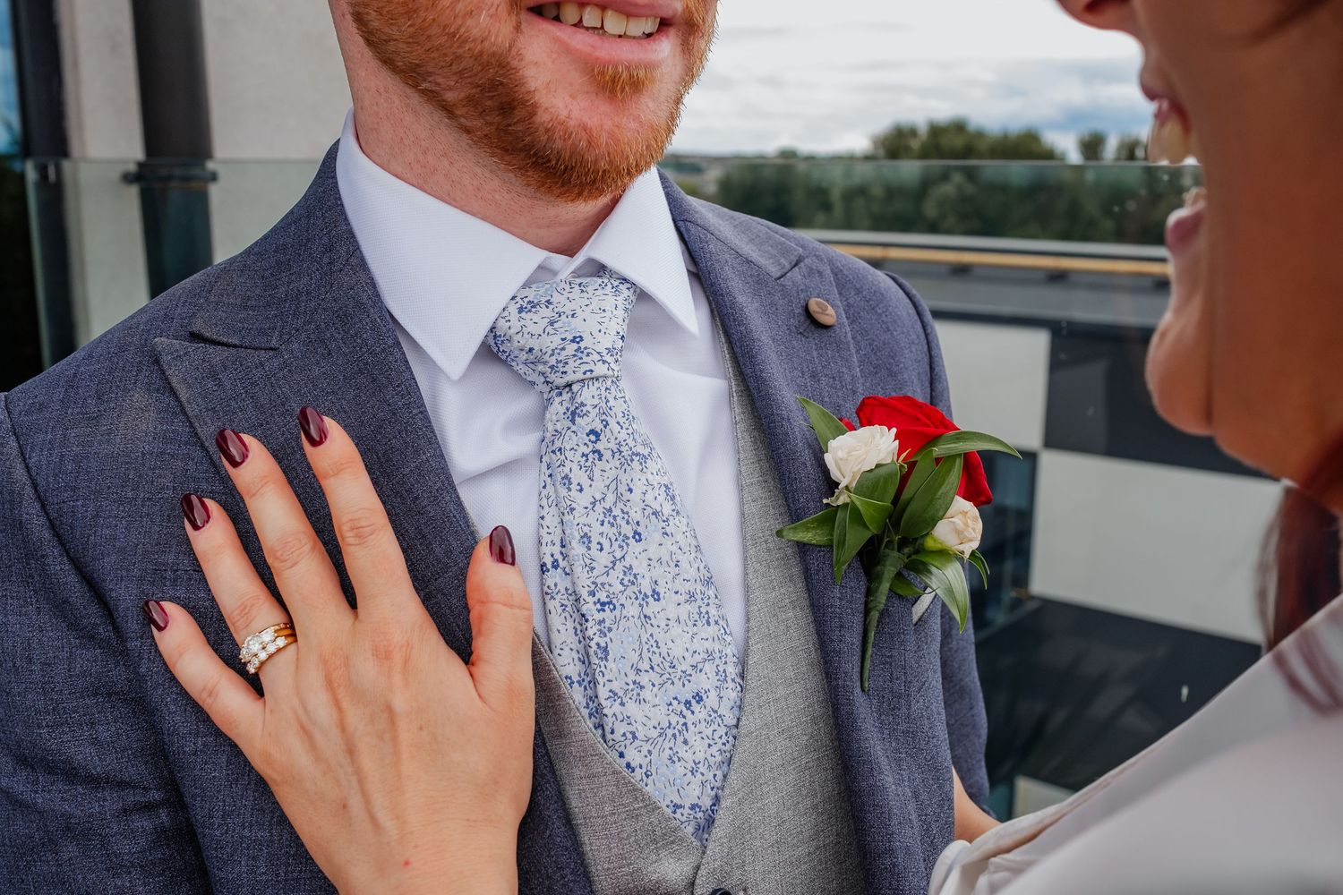 Close-up of couple's tender moment against cloudy outdoor backdrop.