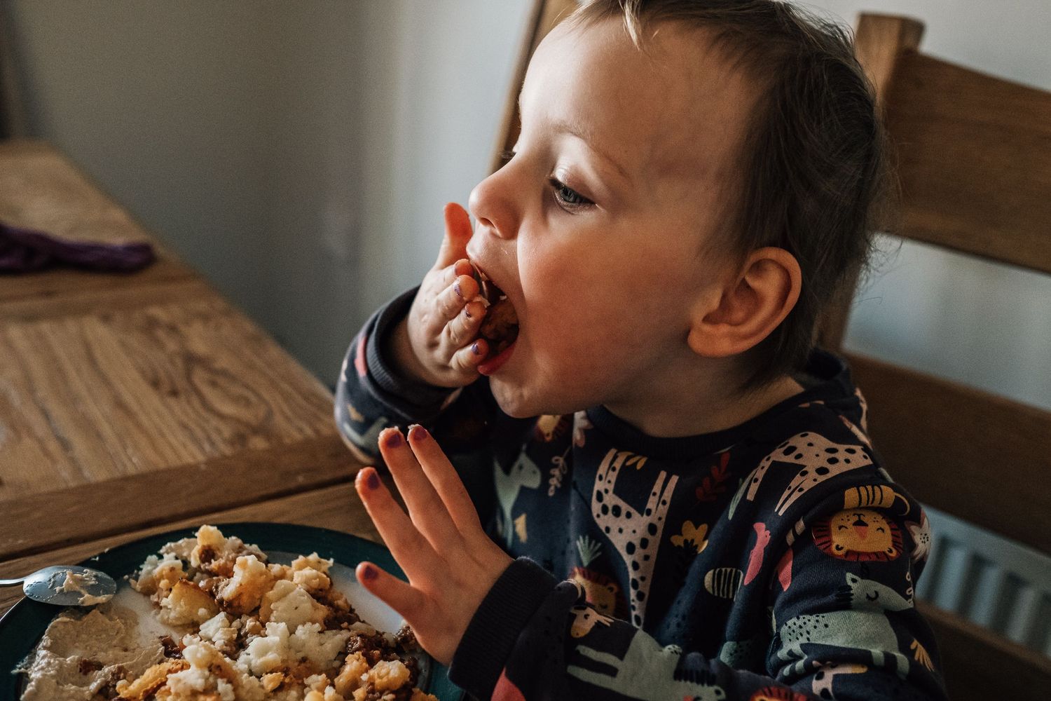 Close up of someone eating popcorn at dining table.