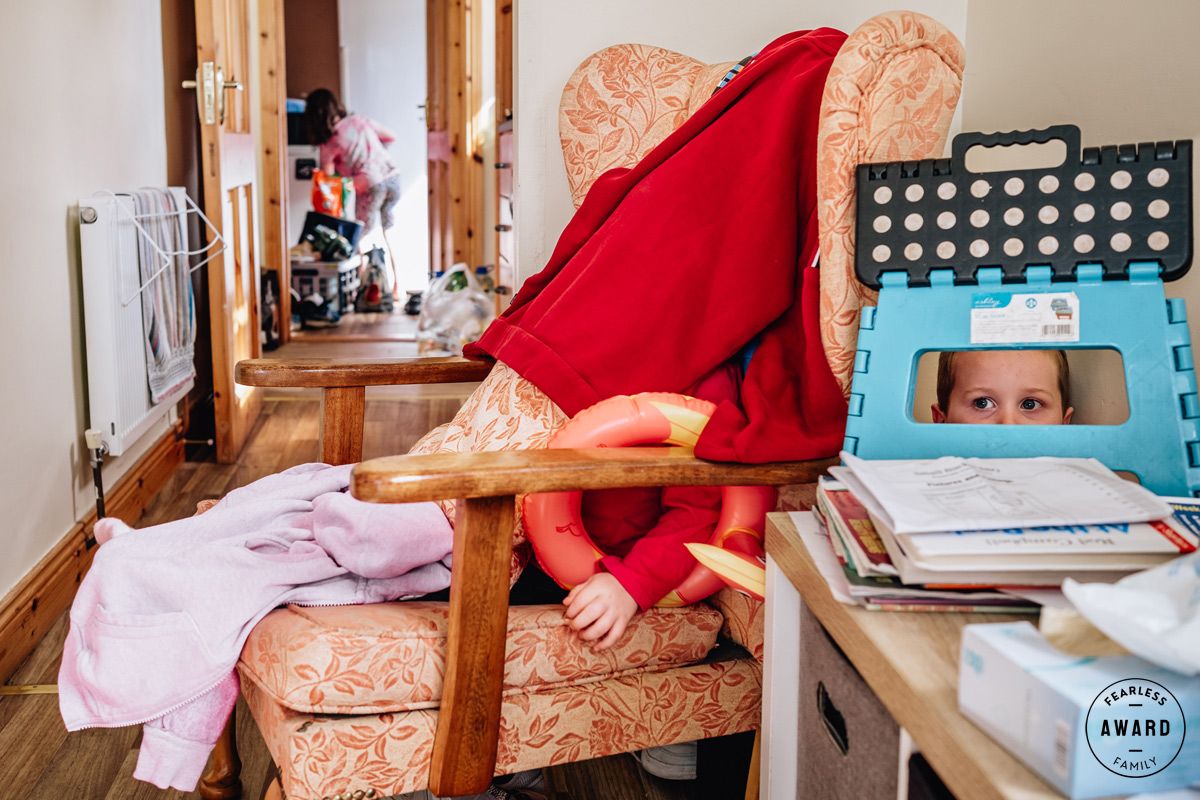 A playful game of hide and seek behind furniture in a cozy living room.