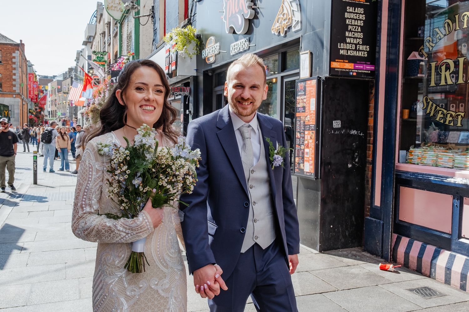 Bride and groom walking through Temple Bar Dublin on wedding day