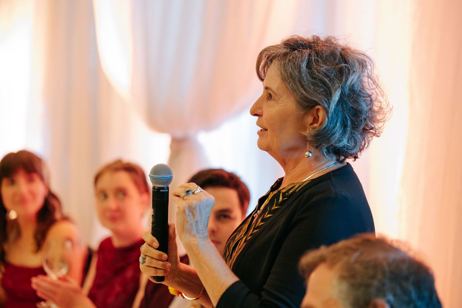 Wedding reception venue with warm lighting and white drapes creating an elegant atmosphere.