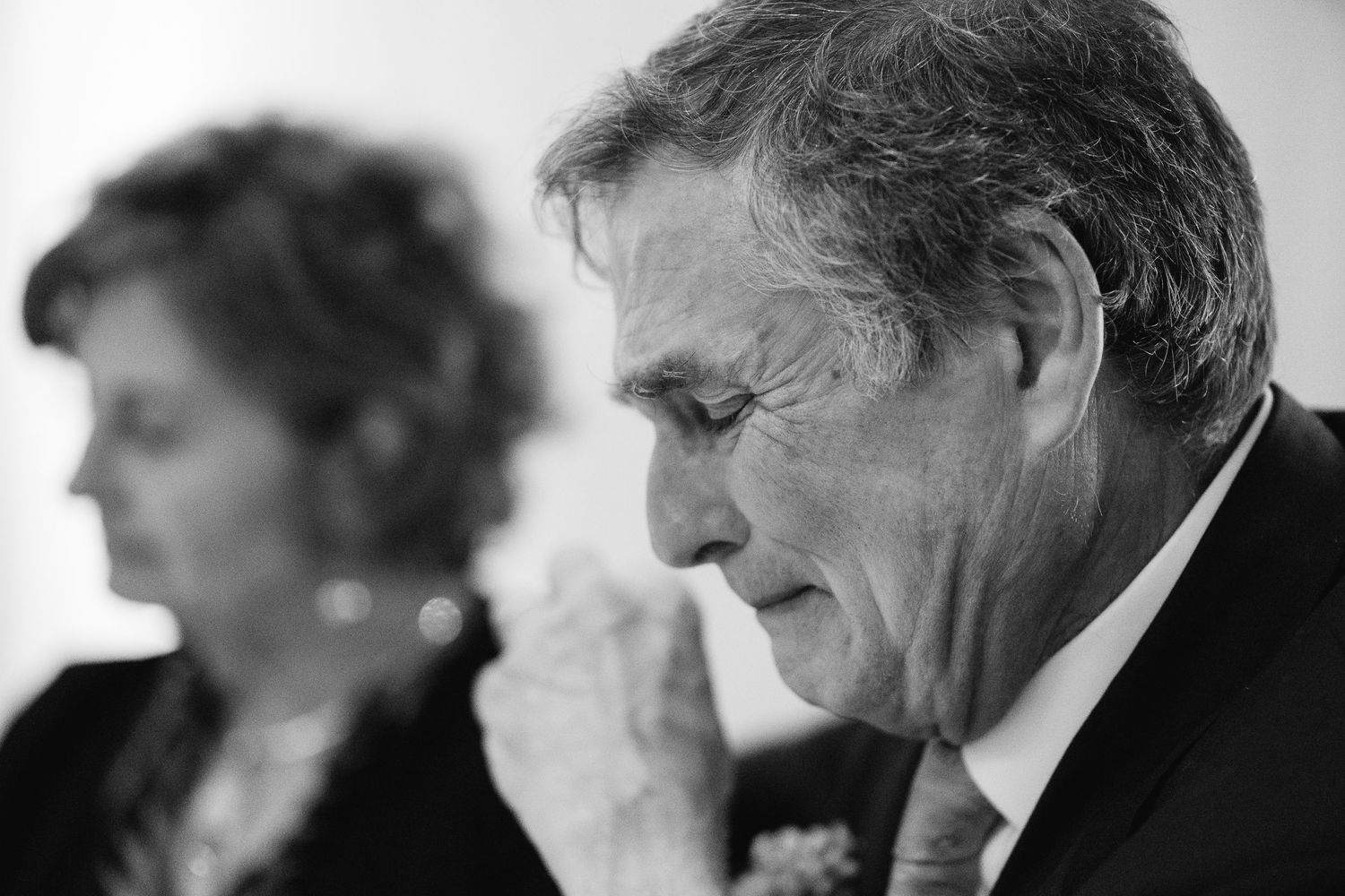 Black and white candid shots of wedding guests during emotional reception moments.