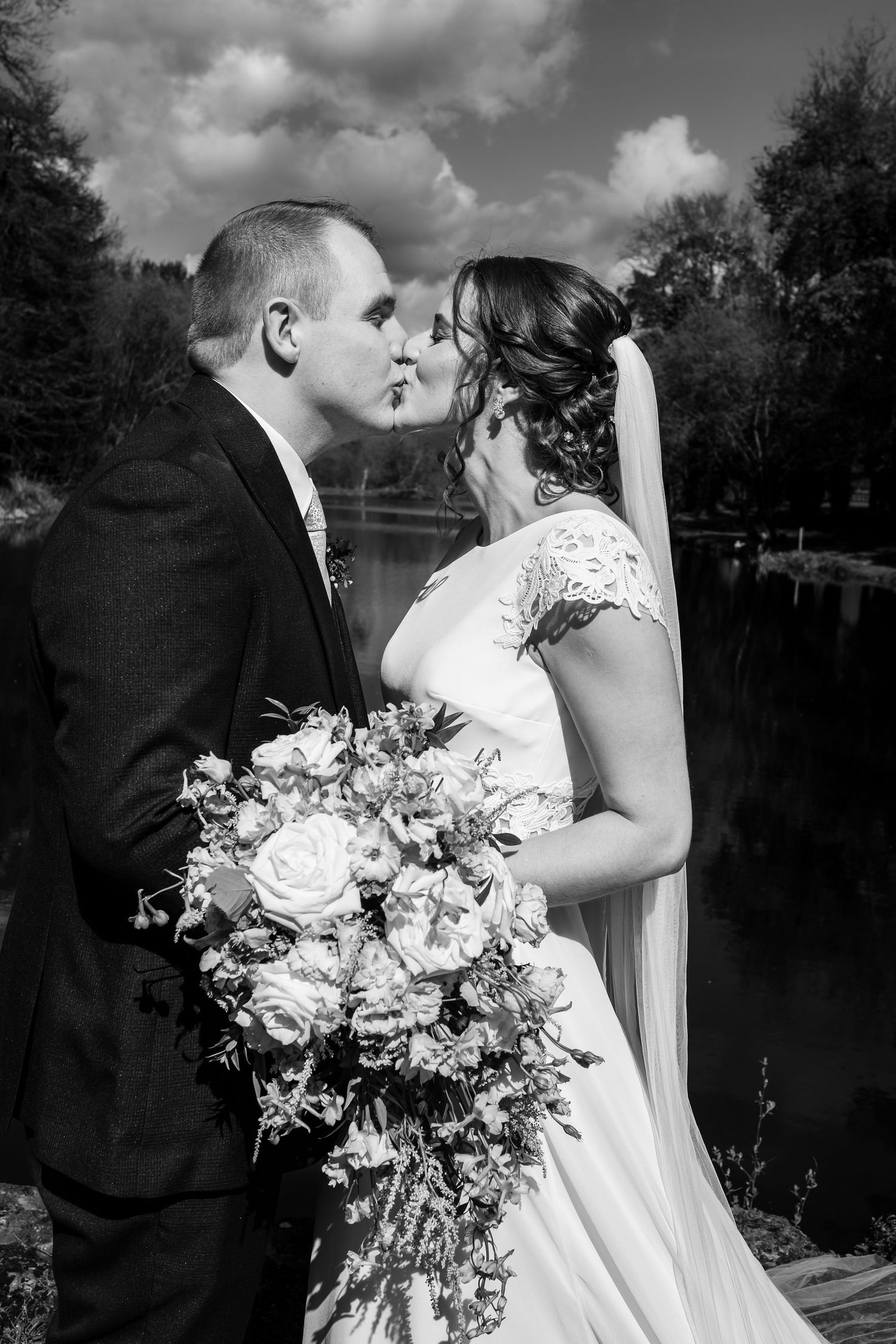 Black and white wedding photography series showing romantic moments by a lake.