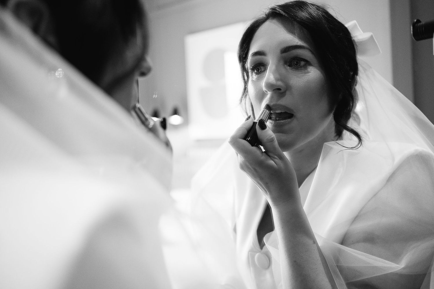 Black and white getting ready photo showing preparation in a bright room.