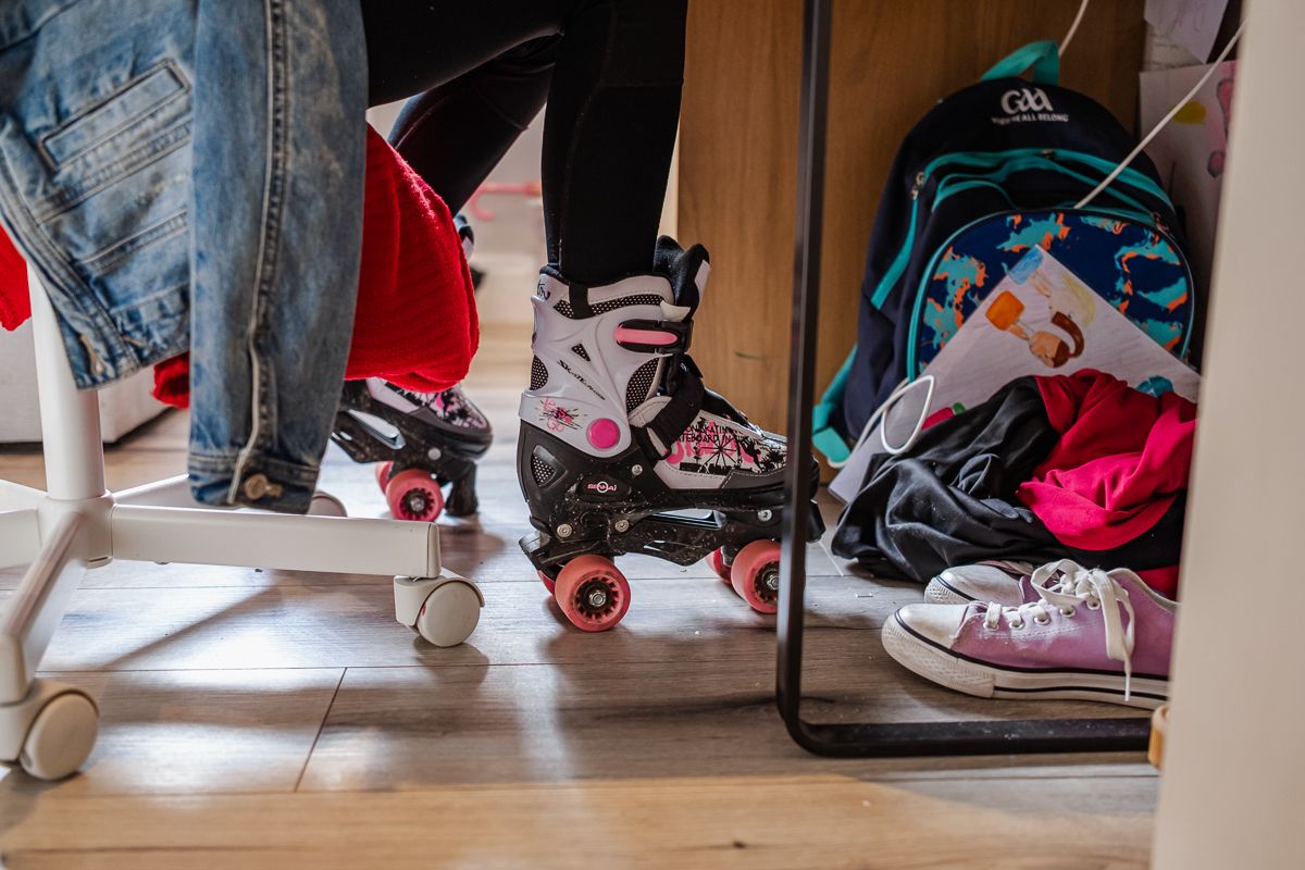 View of feet and shoes underneath furniture during an indoor activity.