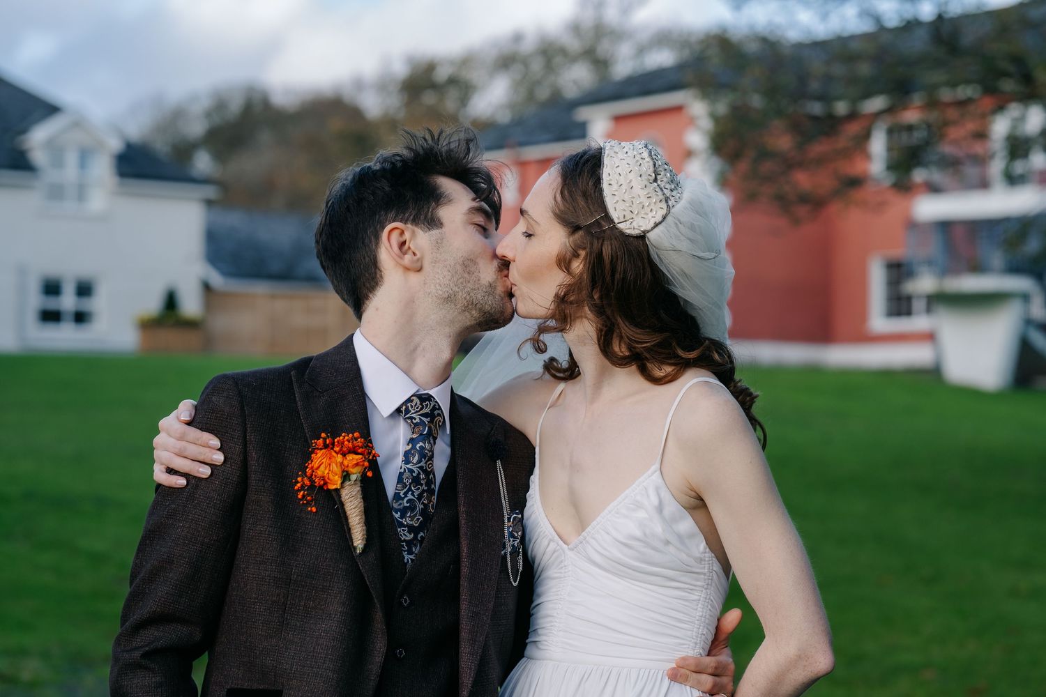 Romantic wedding couple shares intimate moments against scenic rural backdrop.