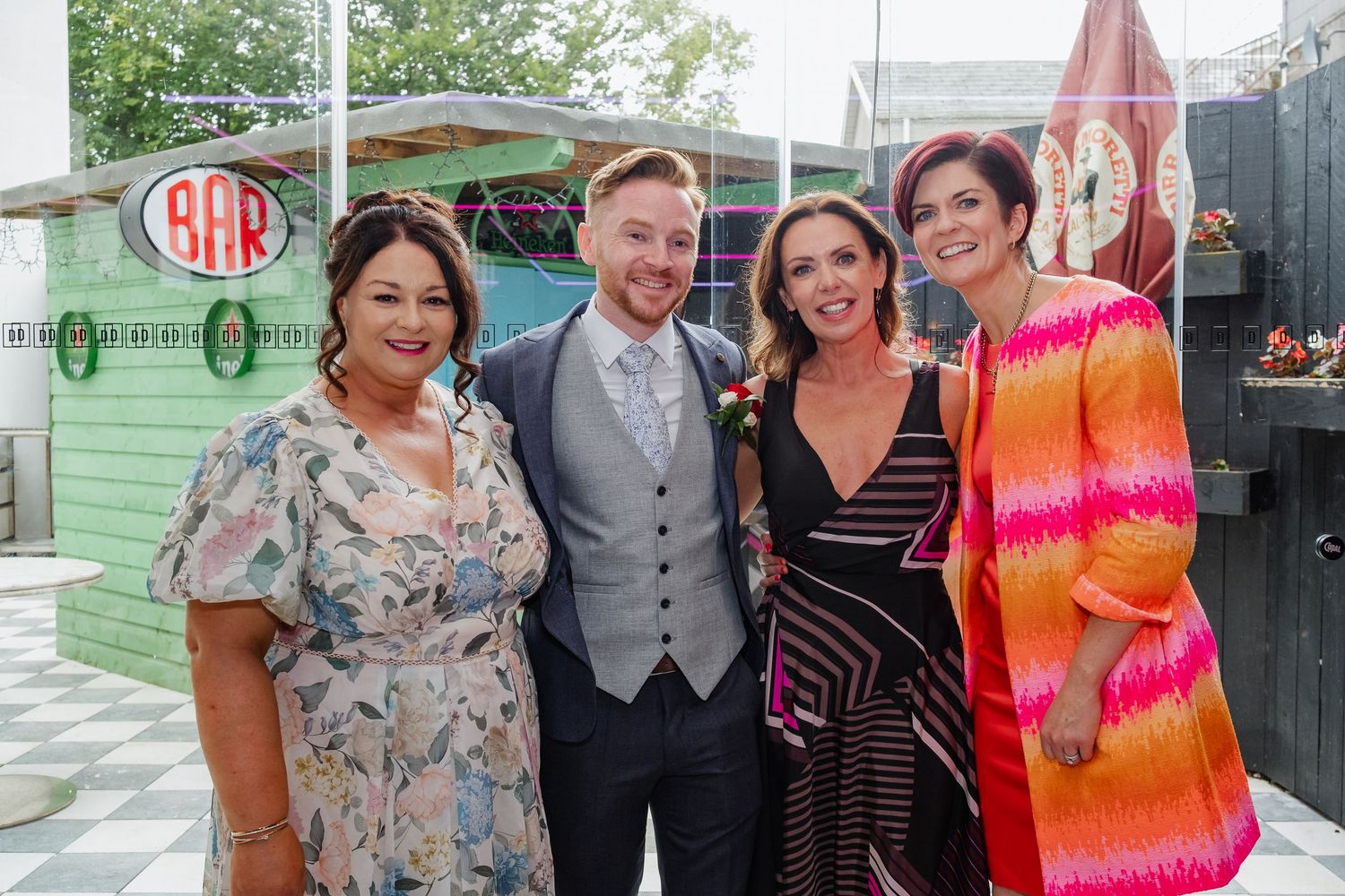 A group of people gather at what appears to be a special event, wearing formal and colorful party attire.