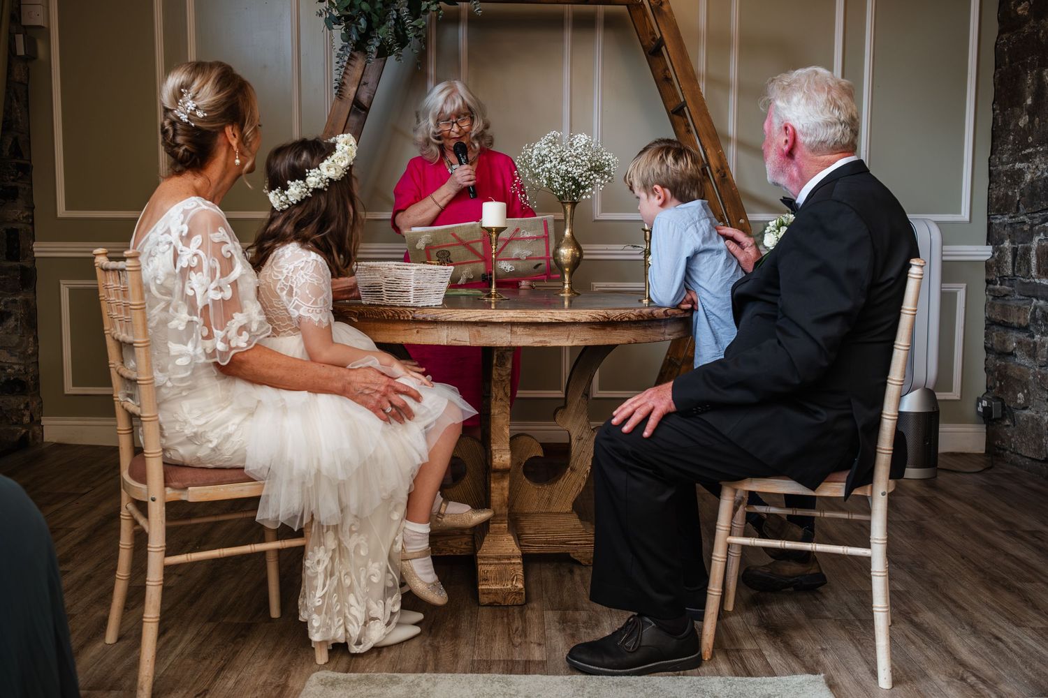 An intimate gathering around a wooden table in an elegant indoor setting.