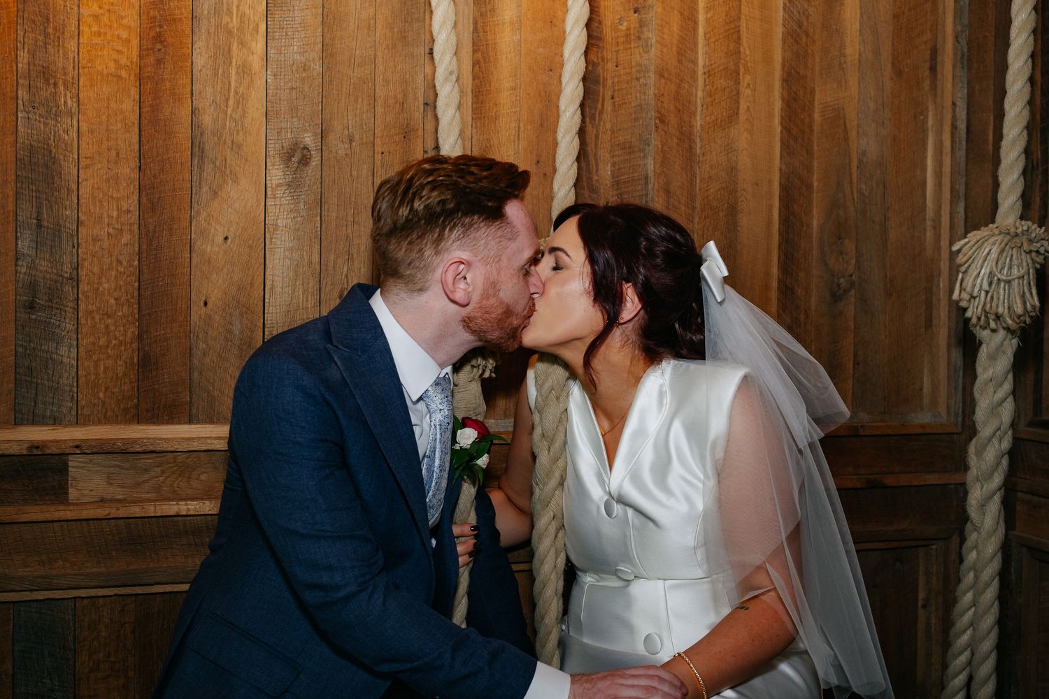 Romantic wedding portraits against rustic wooden wall background.