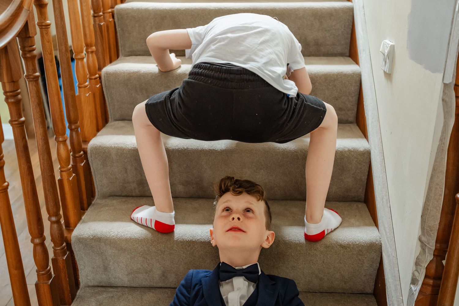 Playful scene on carpeted stairs with creative acrobatic poses.