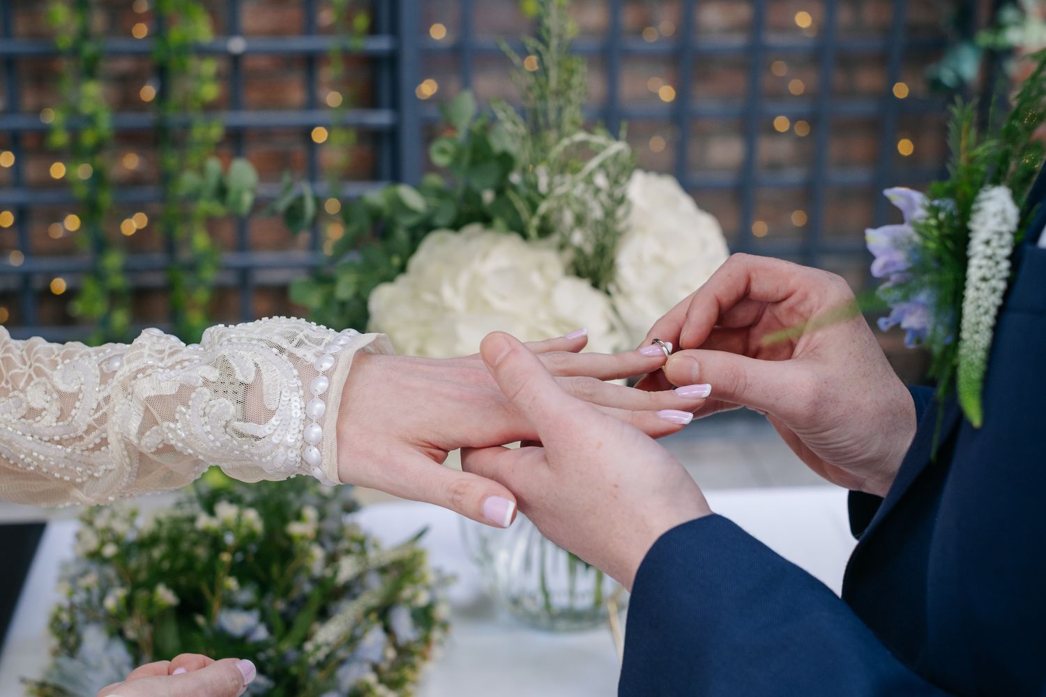 Close-up of hands exchanging wedding rings during an elegant ceremony.