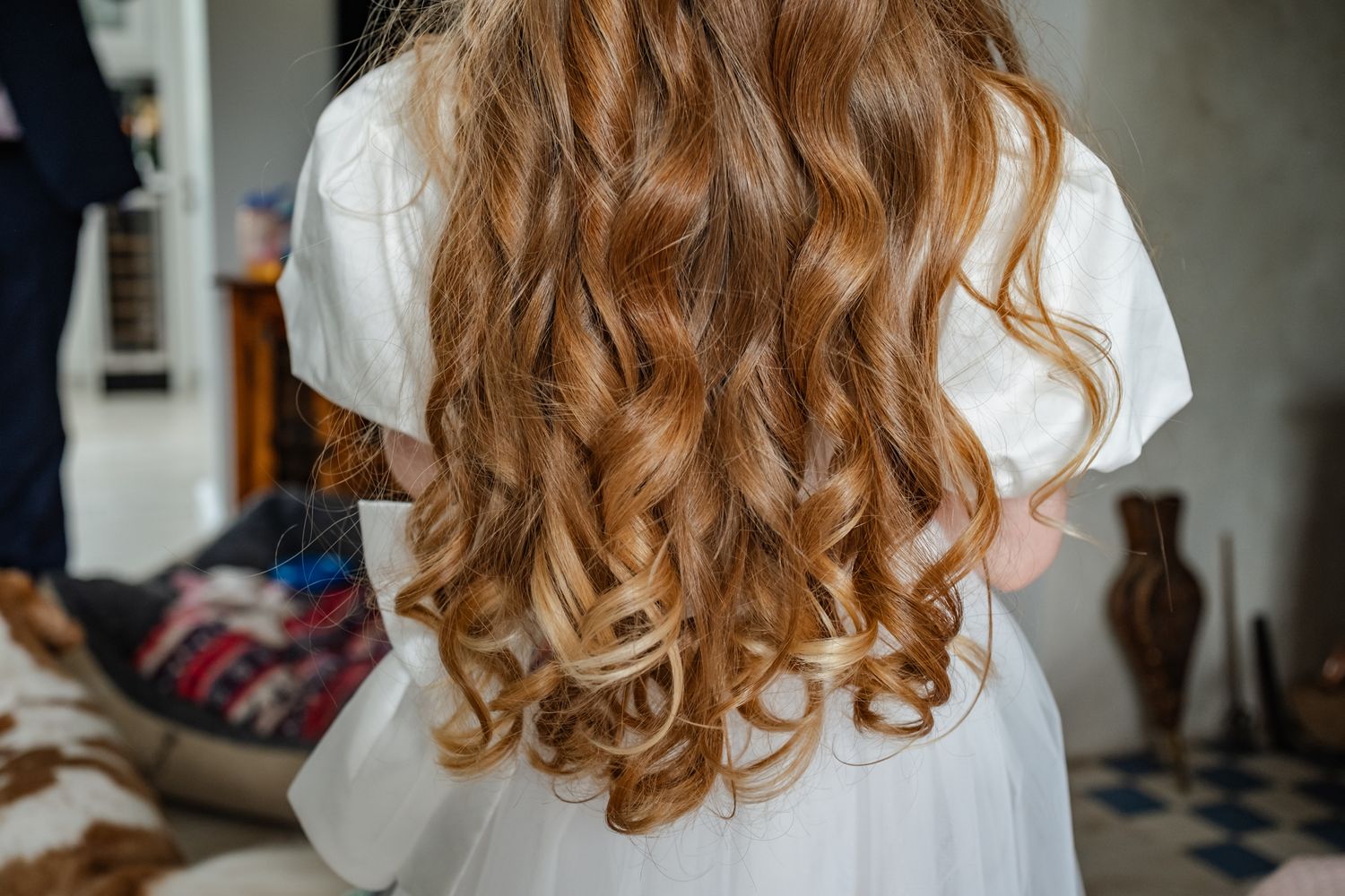 Beautiful cascading honey-blonde curls styled in loose spiral waves seen from behind.