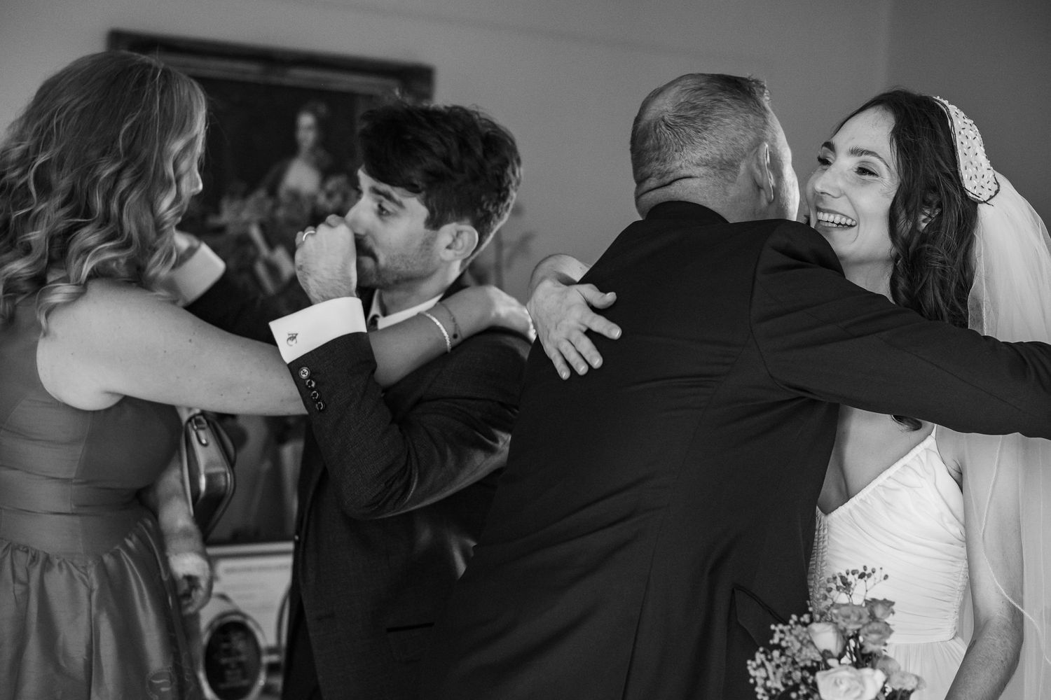 Black and white photo of wedding guests dancing together at a reception celebration.