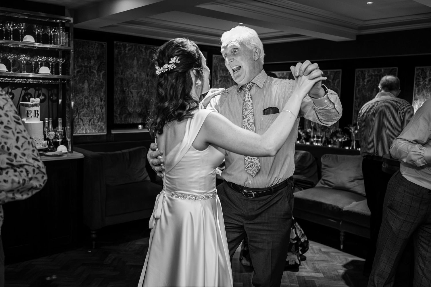 A formal dance captured in black and white showing a couple elegantly moving across the dance floor.