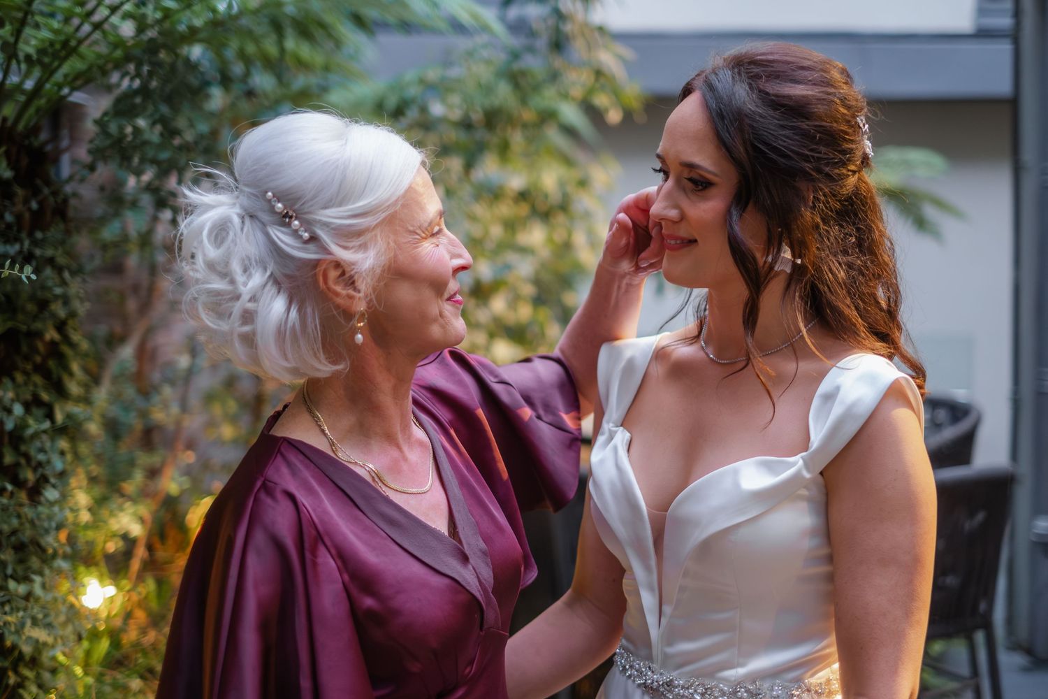An intimate moment between two women in elegant attire during a wedding celebration.