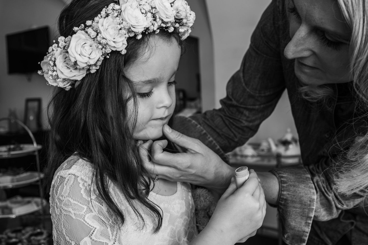Young flower girl getting ready while wearing a delicate floral crown.