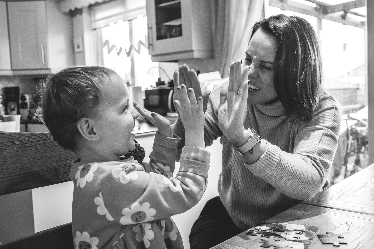 A playful interaction between parent and child at a kitchen counter.