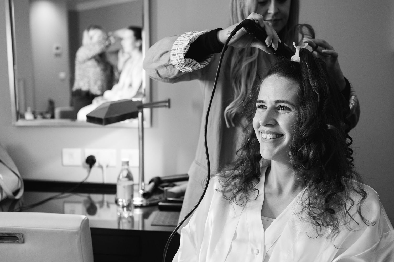 A black and white photo sequence showing preparations for a special occasion with styling and makeup being done.