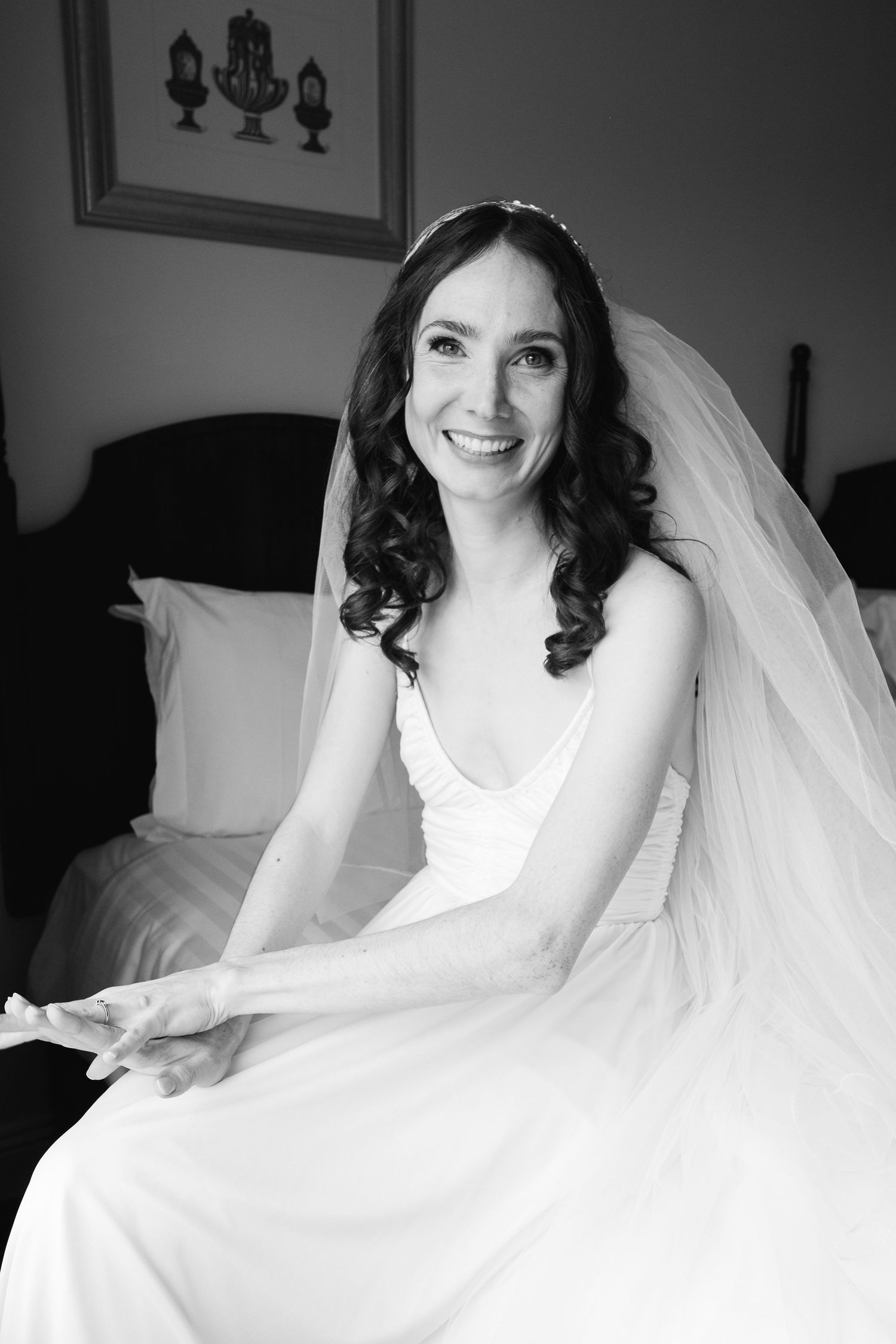 A bridal portrait in black and white showing a flowing veil and white dress.