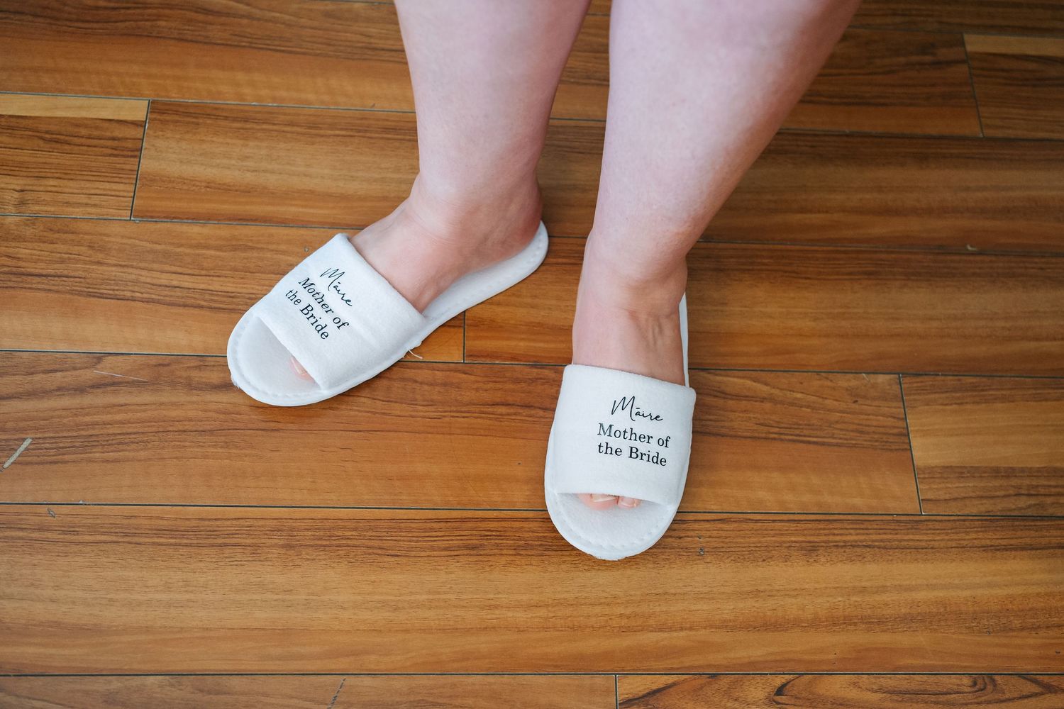 Various angles of custom white wedding socks displayed on hardwood floor.