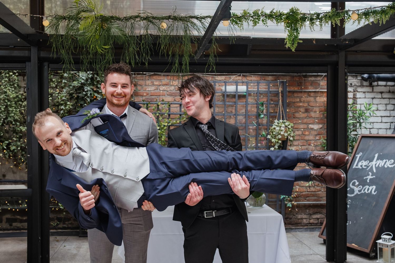 Group photo showcasing playful and energetic poses against a brick wall backdrop.