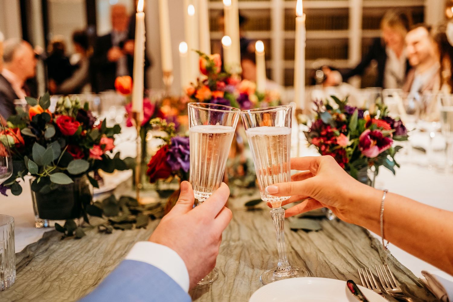 Elegant wedding reception table with candlelight and floral arrangements.