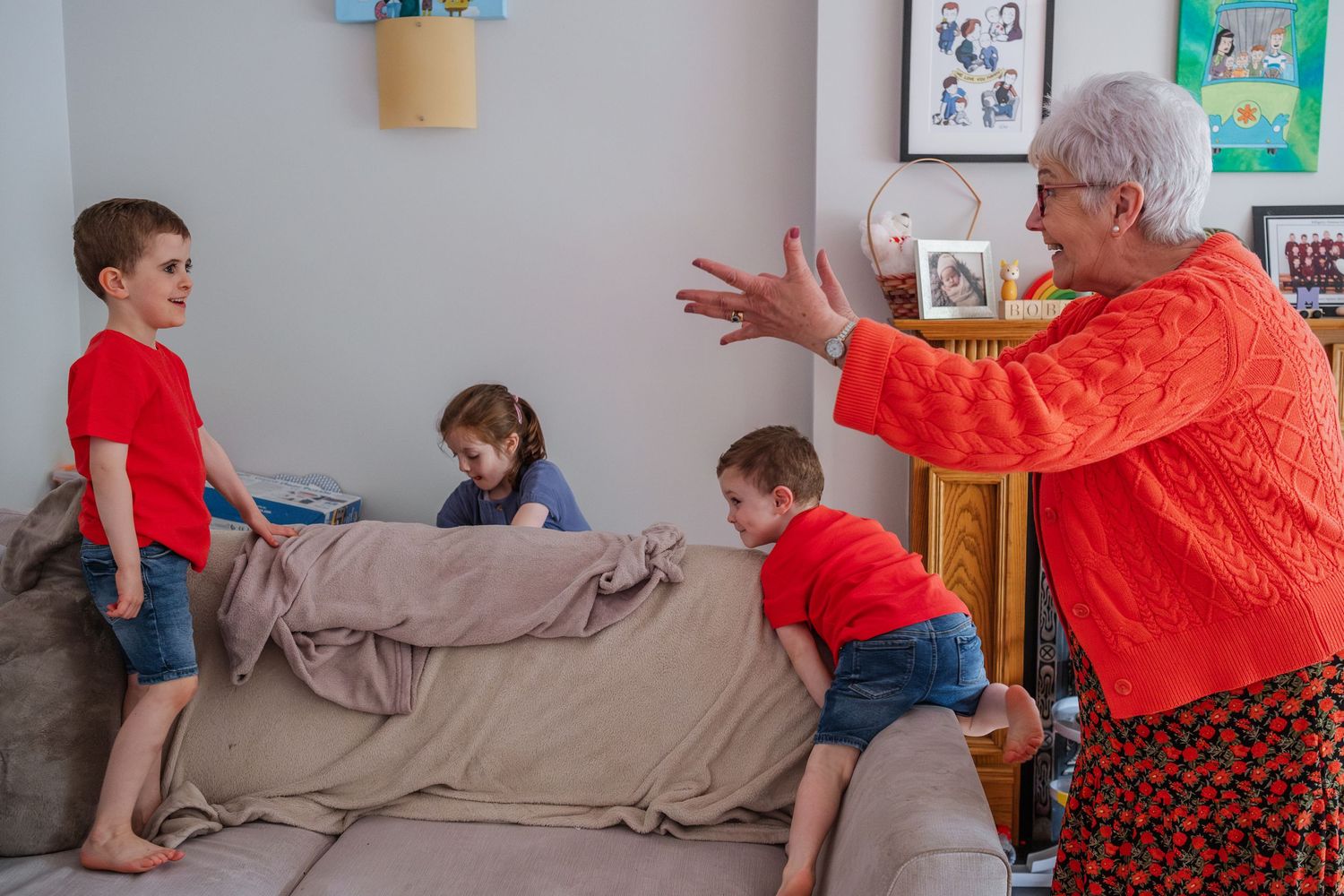 Family enjoying playtime together on a cozy gray couch.