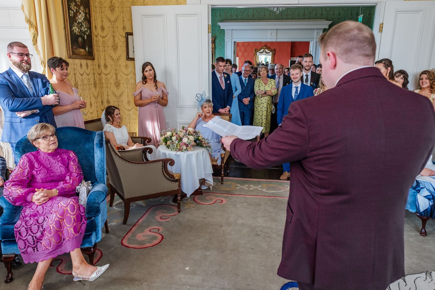People dance and celebrate at a lively indoor party with casual and formal attire visible.