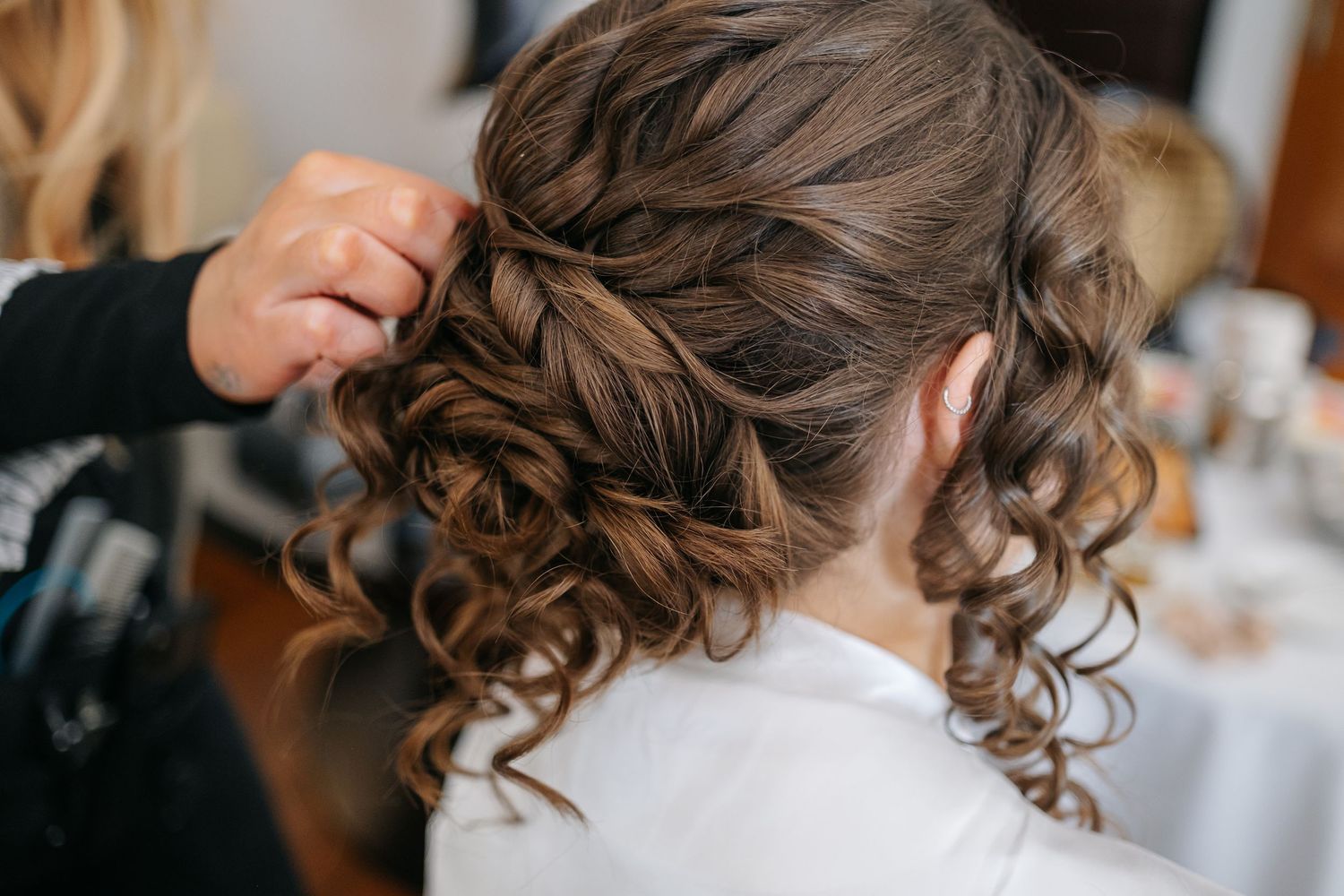 Close up of elegant bridal hairstyle with curled updo and hair accessories.