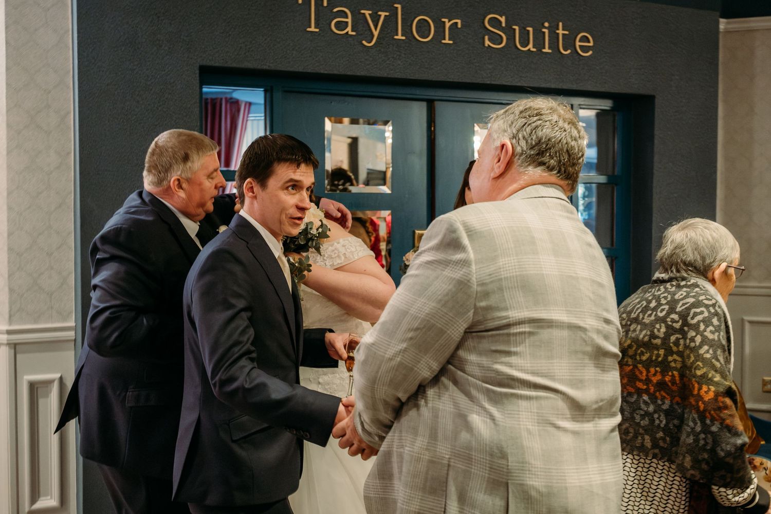 Wedding guests gather and greet each other outside the Taylor Suite entrance.
