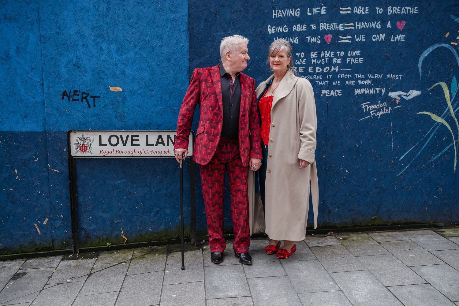 Mural with 'Love Late' text and figures standing against blue wall background.