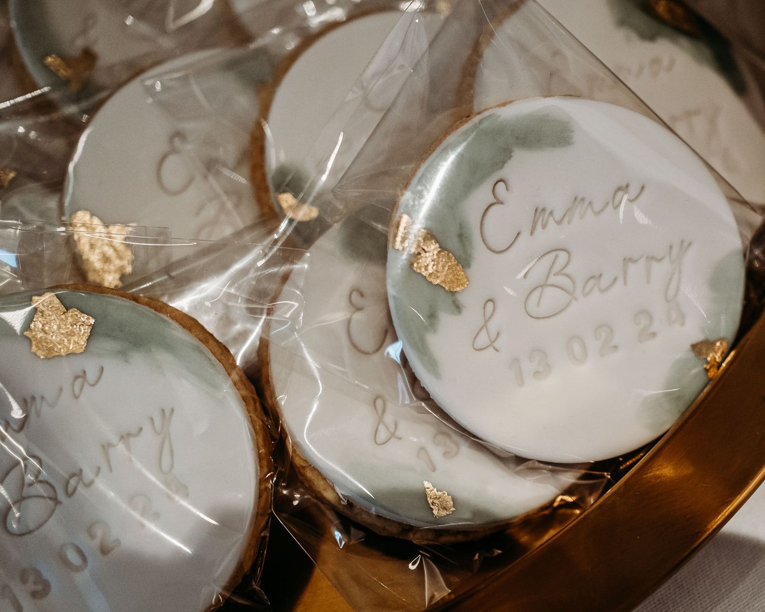 White round cookies or favors with gold details arranged for a wedding celebration.