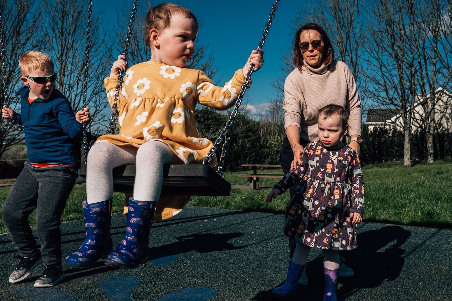 Joyful swinging at a playground on a sunny spring day.