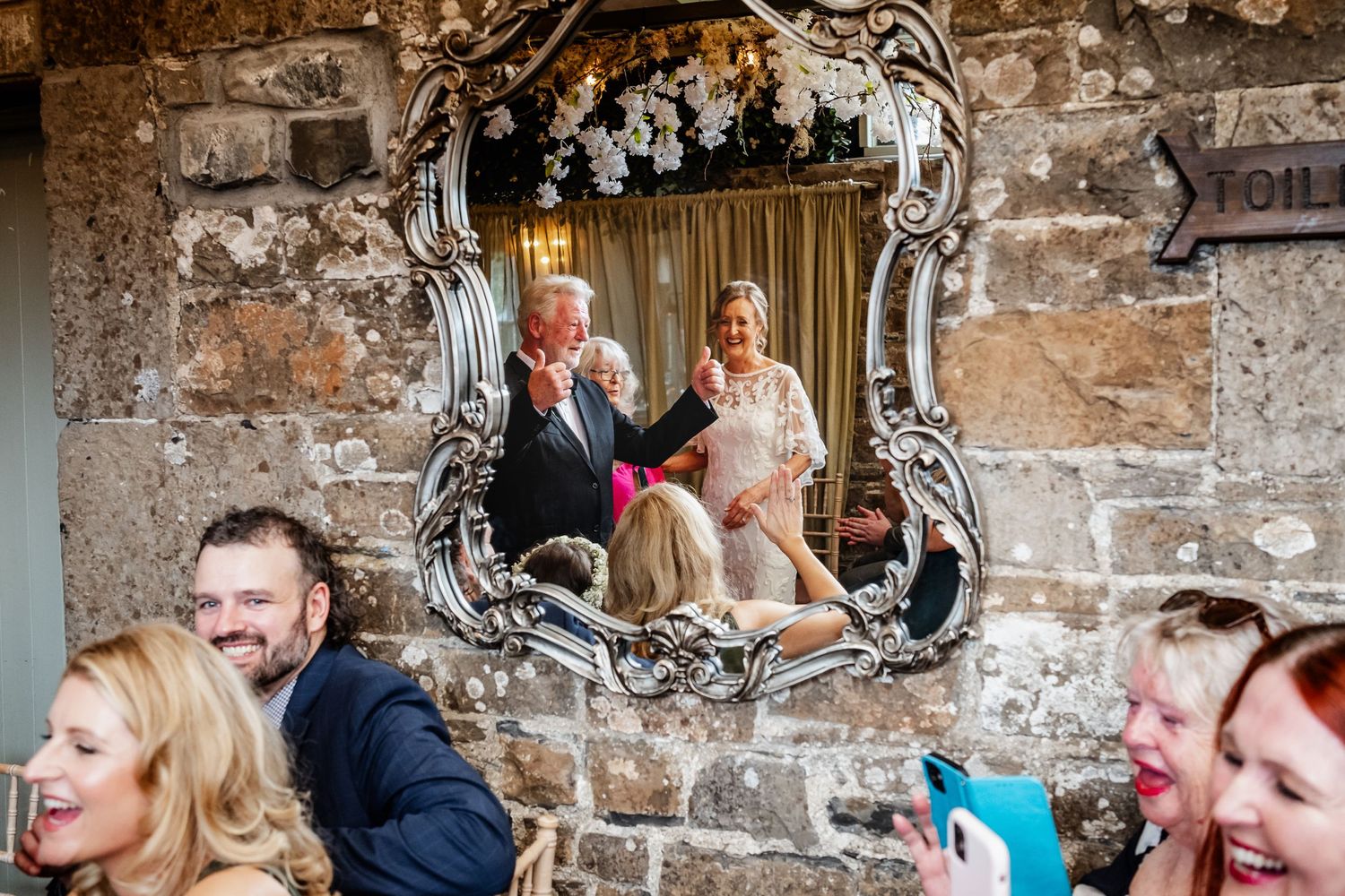Intimate gathering of wedding guests seated in a rustic venue.
