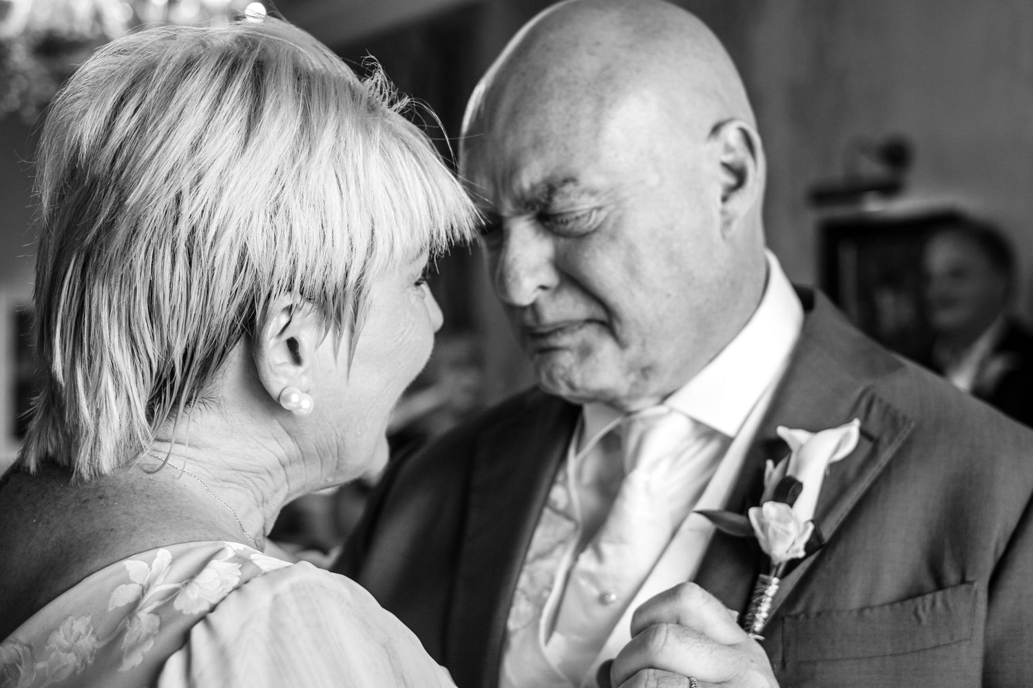 Intimate black and white portrait of mature bride and groom sharing a tender moment on their wedding day.