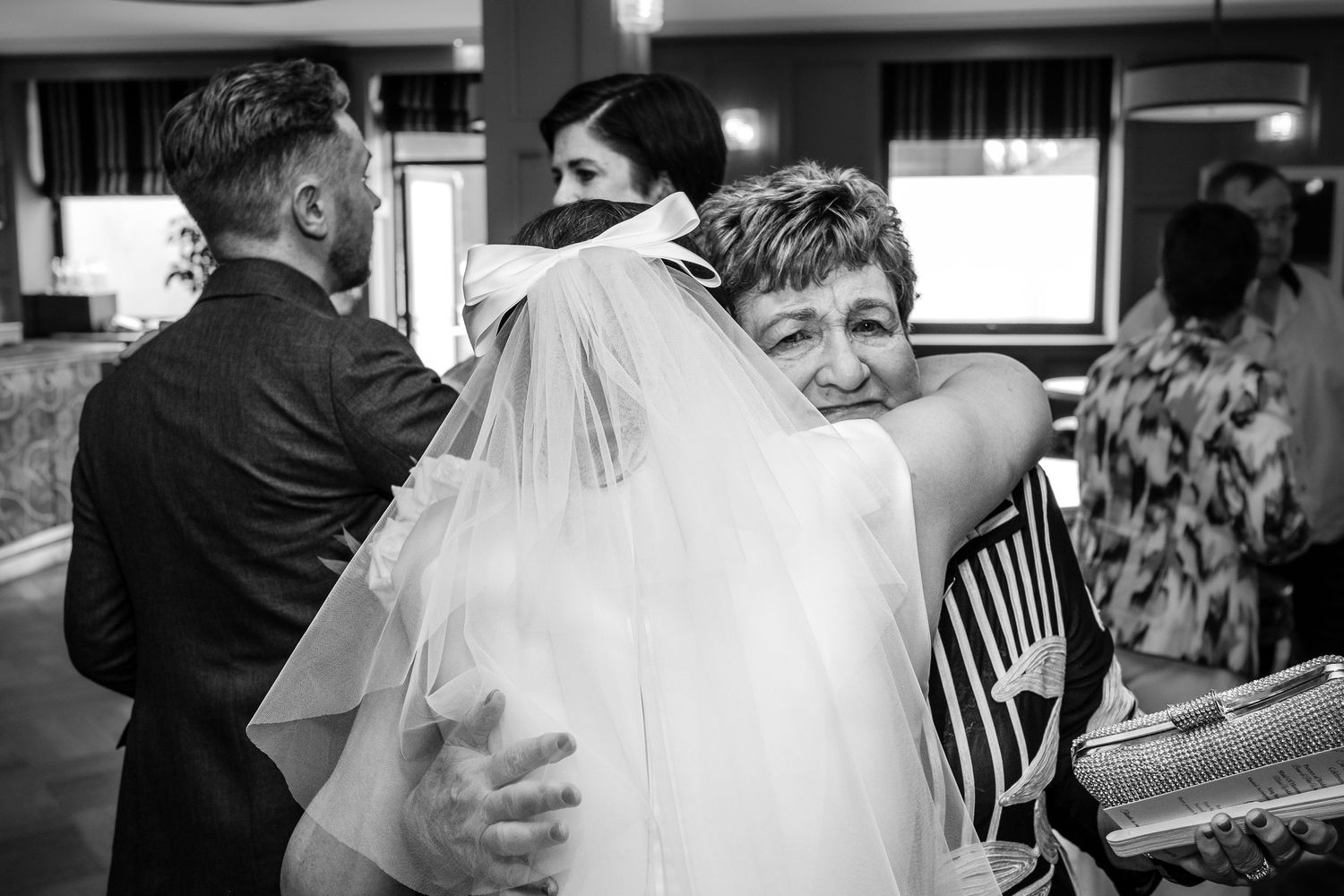 Emotional family hugs and celebrations during wedding reception moments.