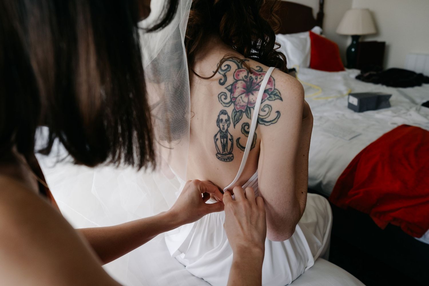 Artistic wedding photography detail shot showing dress fabric and delicate hand placement.